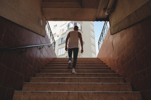 Young man climbing stairs in pedestrian subway