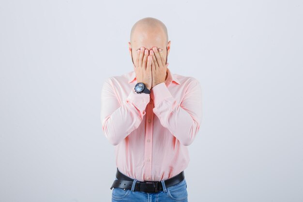 Young man covering face with hands