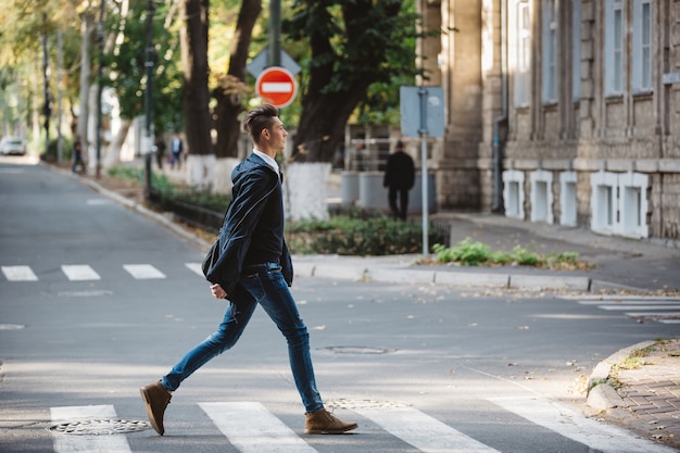 Молодой человек переходит улицу