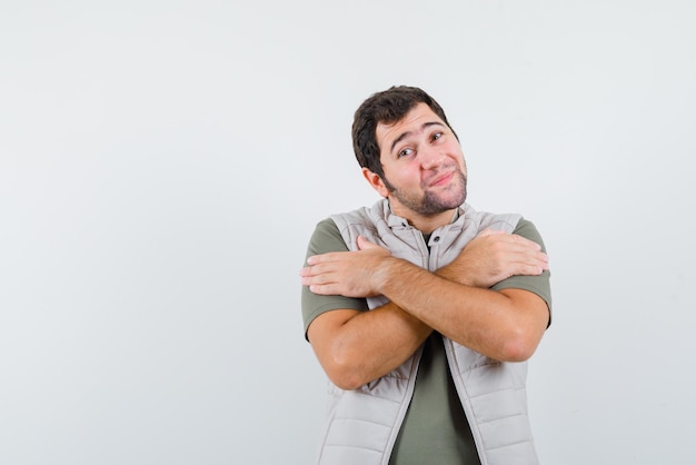 Young man crossing his arms on white background