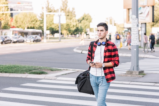 Young man crossing street