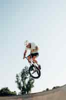 Free photo young man cycling in skatepark low angle shot