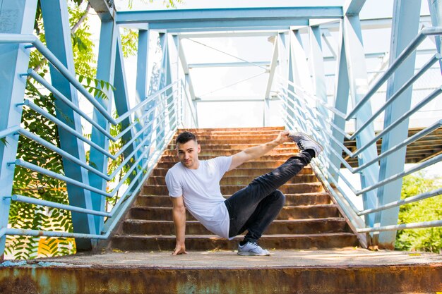 Young man dancing on bridge