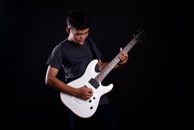молодой человек в темной футболке с электрической гитарой