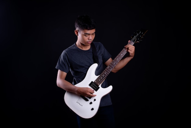 young man in dark t shirt with electric guitar