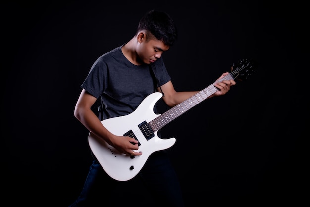 young man in dark t shirt with electric guitar