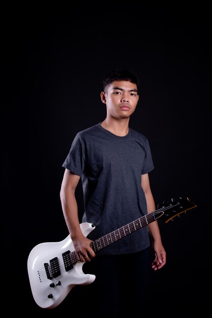 일렉트릭 기타와 함께 어두운 티셔츠에 젊은 남자
