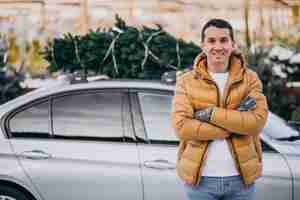 Бесплатное фото Молодой человек доставки елки на автомобиле