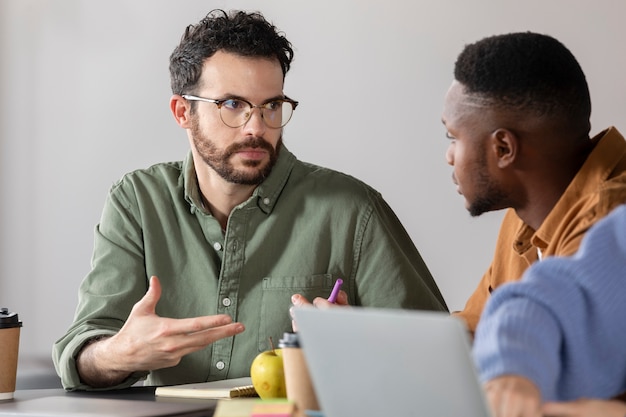 Free photo young man discussing with his colleague during study session