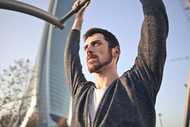 Young man does gymnastics in a park