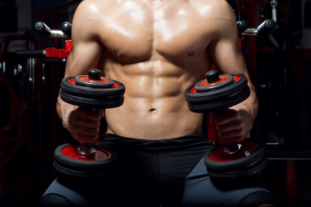 Free photo young man doing heavy weight exercise in gym.