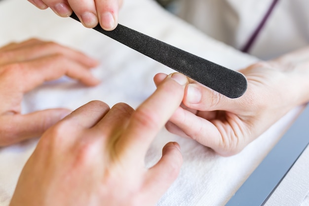 Young man doing manicure in salon. Beauty concept.