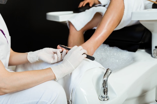 Free photo young man doing pedicure in salon. beauty concept.