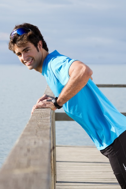 Young man doing push ups near the sea