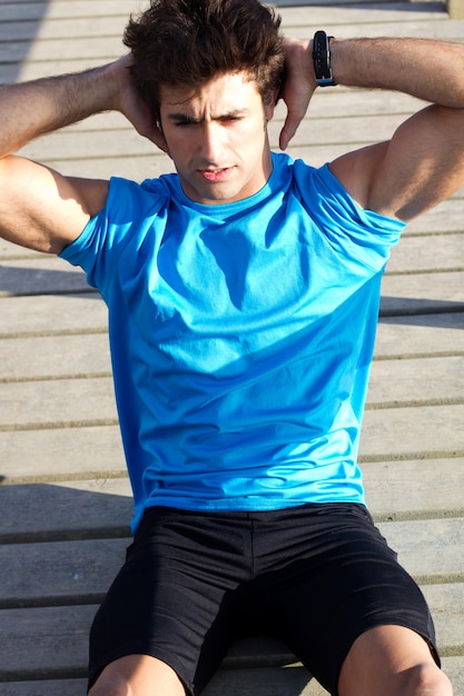 Free photo young man doing push ups near the sea