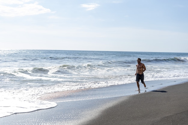 해변에서 달리기 운동을 하는 청년