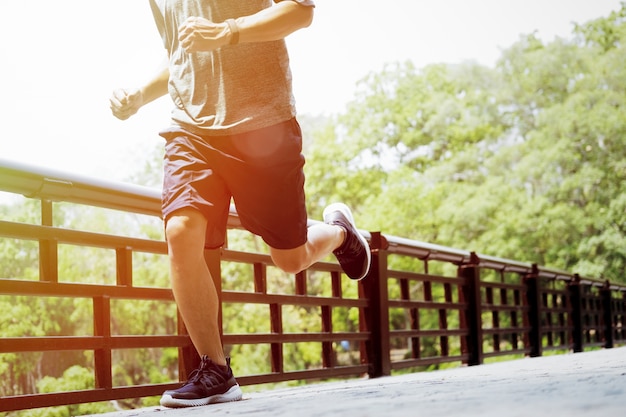 Young man doing sports and jogging, runing in a park.