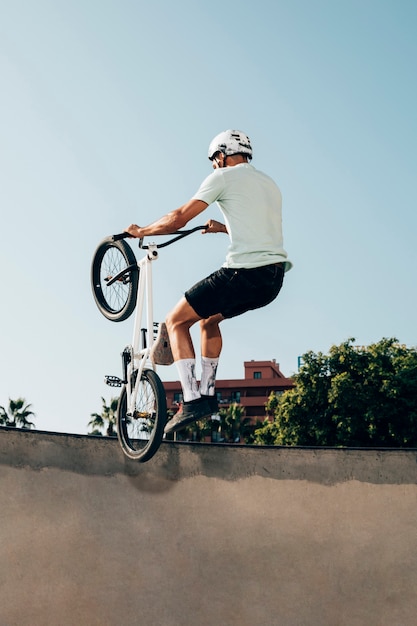 Free photo young man doing tricks on his bicycle