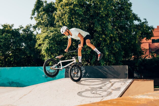 若い男がbmxバイクでトリックを行う