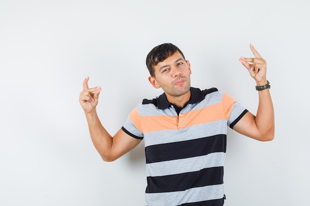 Free photo young man doing yoga gesture in t-shirt and looking cheerful