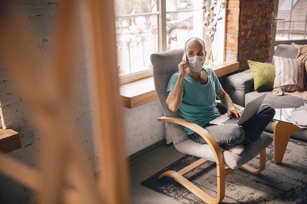 Free photo young man doing yoga at home while being quarantine and freelance working