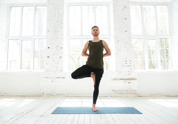 Young man doing yoga or pilates exercise