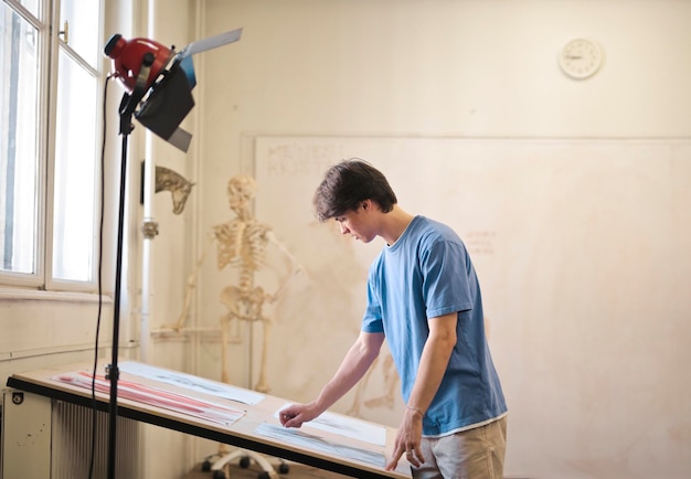 Free photo young man draws a skeleton in school