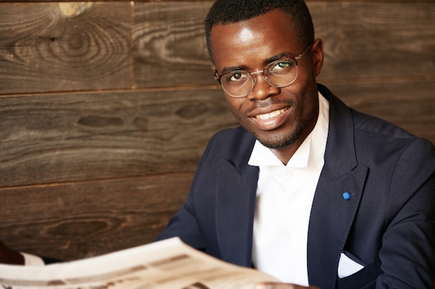 Free photo young man dressed in formal suit sitting in cafe