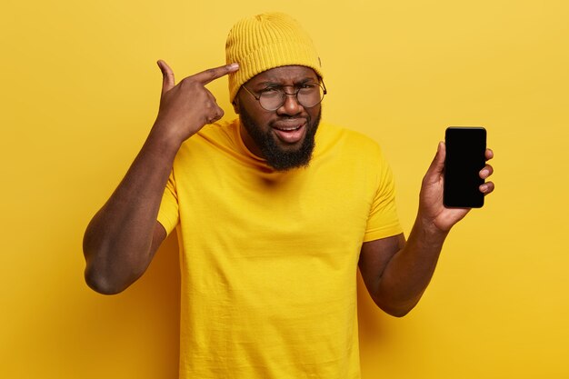 Young man dressed in yellow holding phone