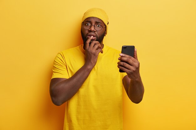 黄色の携帯電話に身を包んだ若い男