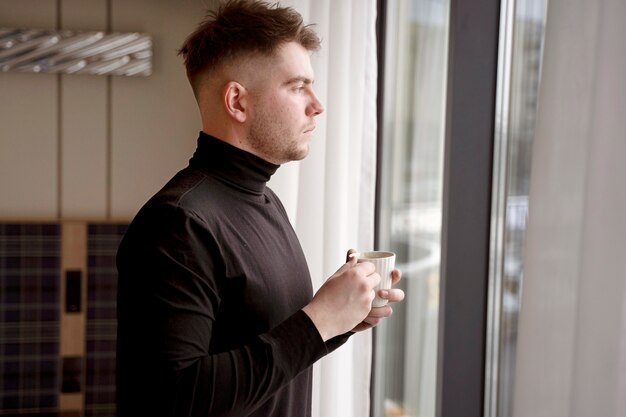 Young man drinking coffee in a hotel room