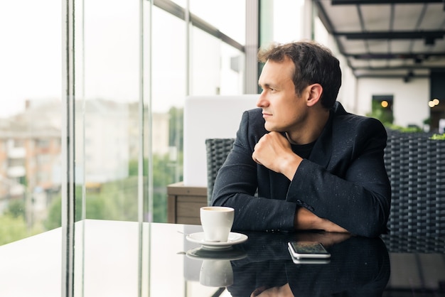 Young man drinking a cup of coffee in the cafe