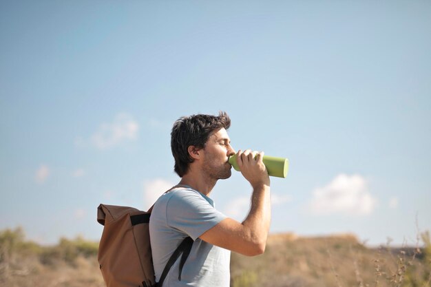 young man drinks from a flask