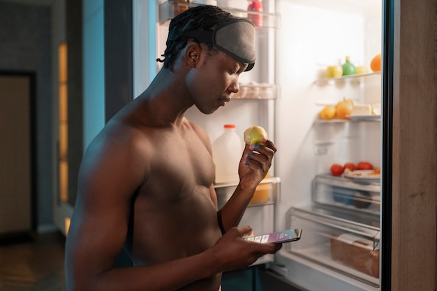 Young man enjoying a snack at home in the middle of the night