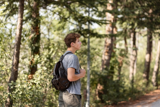 Free photo young man enjoying walk in the forrest