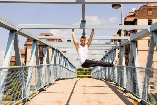 Young man exercising on the bridge