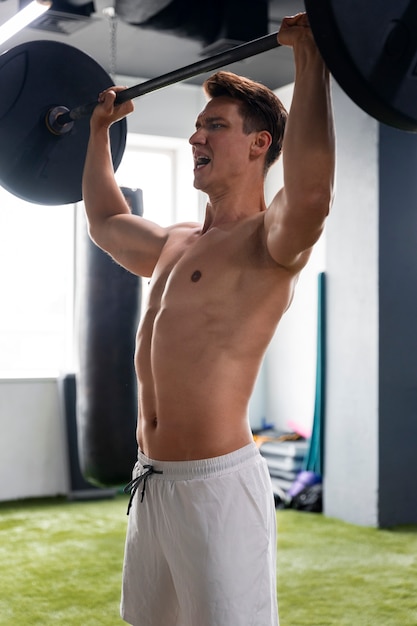 Free photo young man exercising at the gym for bodybuilding