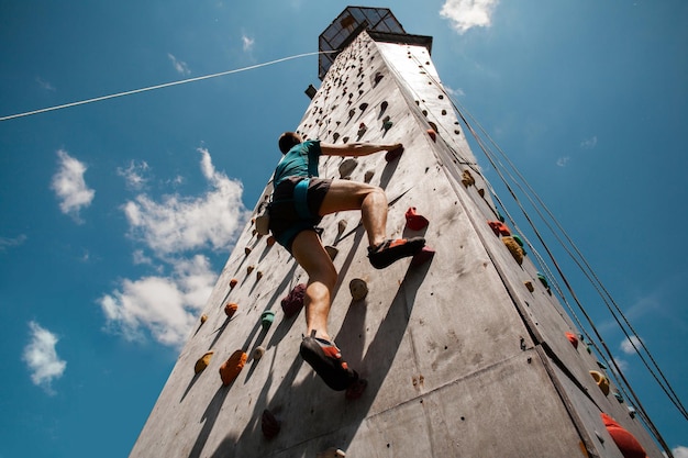 屋内クライミングジムで運動する若い男