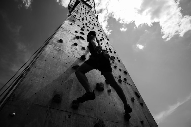 屋内クライミングジムで運動する若い男