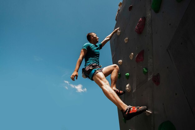 屋内クライミングジムで運動する若い男