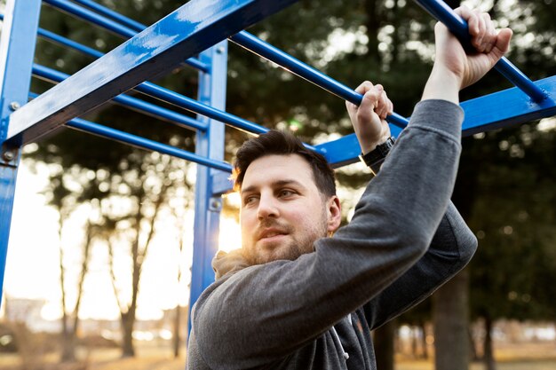 Молодой человек тренируется на открытом воздухе в парке