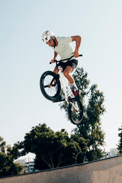 Young man extreme jumping with bicycle low angle view