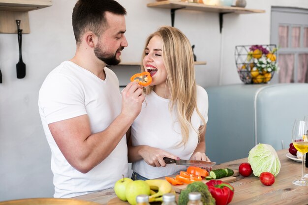 ピーマンと女性に餌をやる若い男