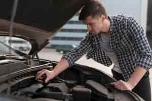 Free photo young man fixing car