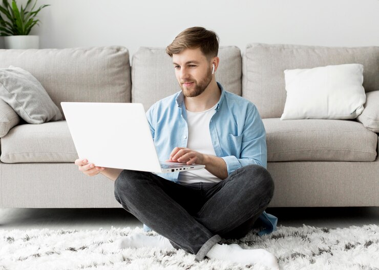 Free Photo young man on floor with laptop