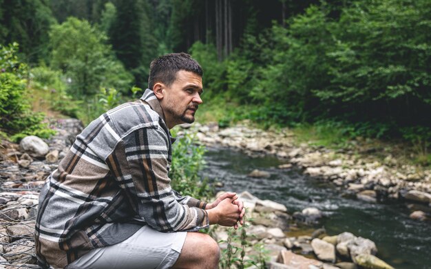 강 근처 숲에서 젊은 남자는 자연을 즐긴다
