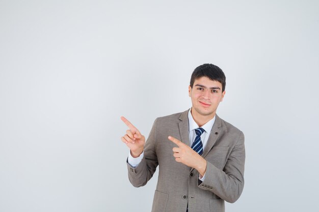 Young man in formal suit pointing left with index fingers