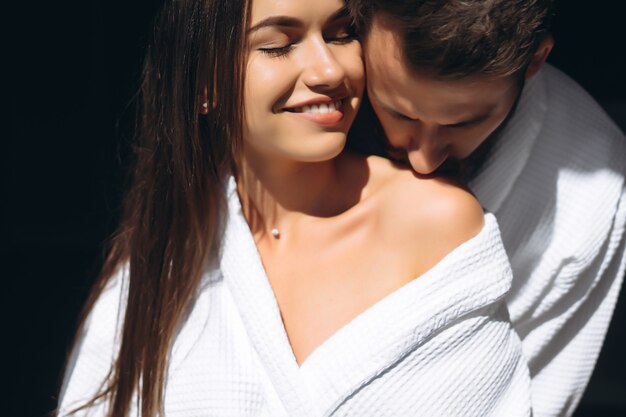 Молодой человек нежно целует красивую женщину на плечо