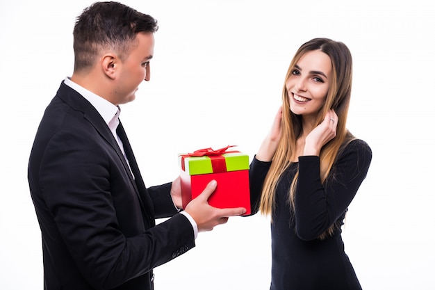 Young man and girl couple unexpected present gift in red box on white