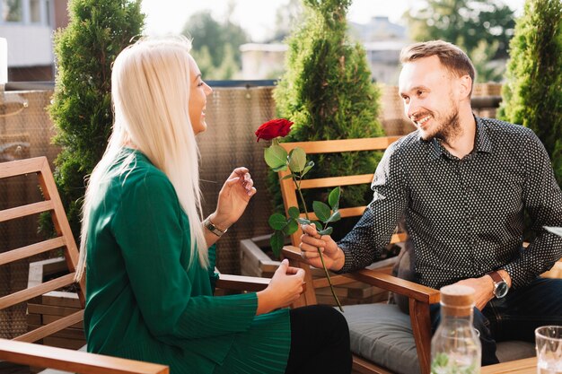 Young man giving beautiful rose to attractive lady